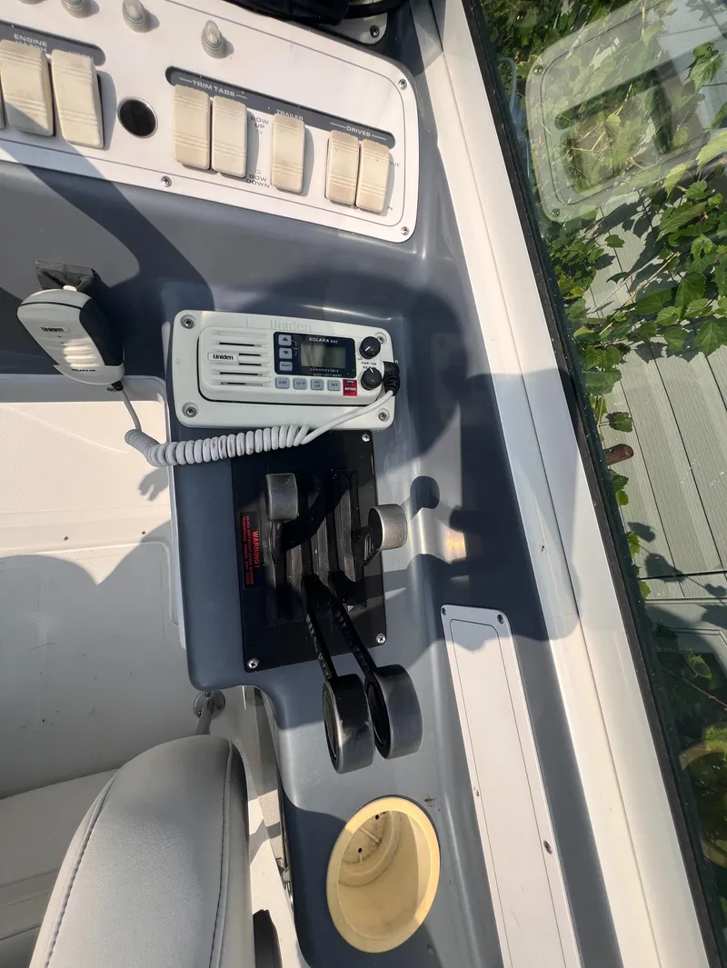 Slide: The Image of 1995 Powerquest 290 Enticer FX boat dashboard with controls and radio. - 3