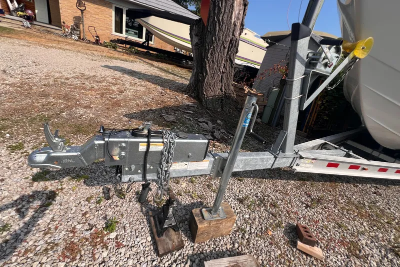 Slide: The Image of Trailer hitch of a 1995 Powerquest 290 Enticer FX boat on gravel driveway. - 31