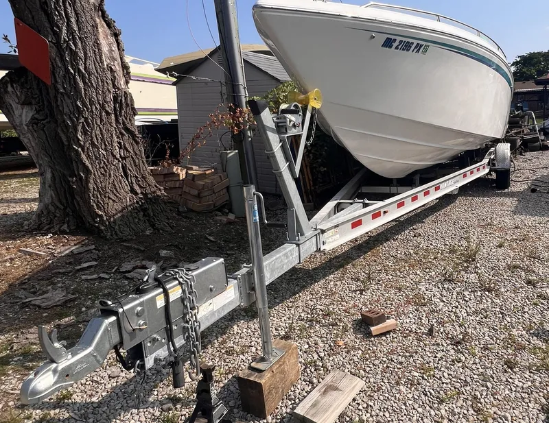 Slide: The Image of 1995 Powerquest 290 Enticer FX boat on trailer in gravel lot. - 32