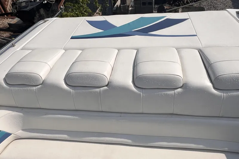 Slide: The Image of 1995 Powerquest 290 Enticer FX boat with white cushioned seating and blue accents. - 7