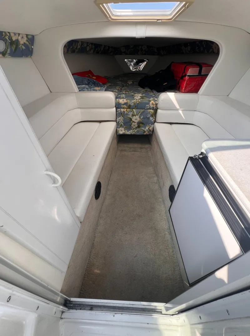 Slide: The Image of Interior of 1995 Powerquest 290 Enticer FX boat with white seating and floral bedding. - 8