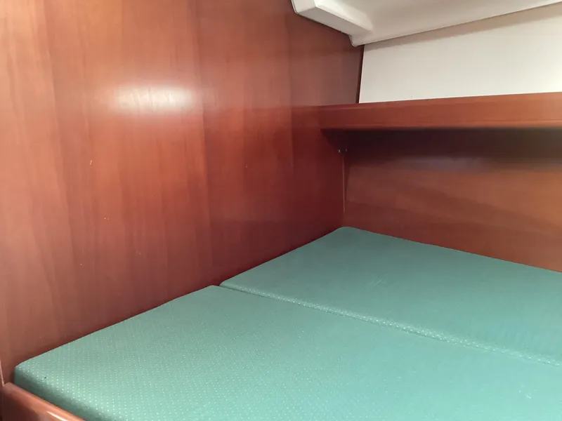 Slide: The Image of Interior cabin of 2002 Beneteau 393 sailboat with wooden walls and green cushions. - 11