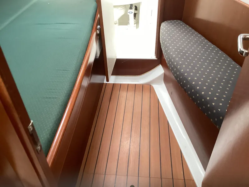 Slide: The Image of Interior of 2002 Beneteau 393 sailboat with wood flooring and cushioned seating. - 13