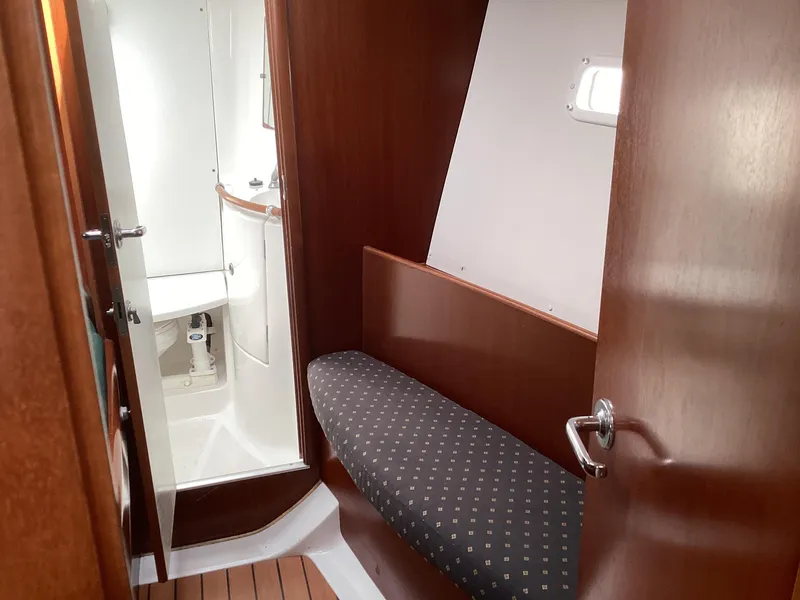 Slide: The Image of Interior of 2002 Beneteau 393 sailboat with wooden finish and compact bathroom. - 14