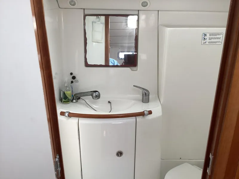 Slide: The Image of Beneteau 393 2002 yacht bathroom with sink, mirror, and storage. - 18