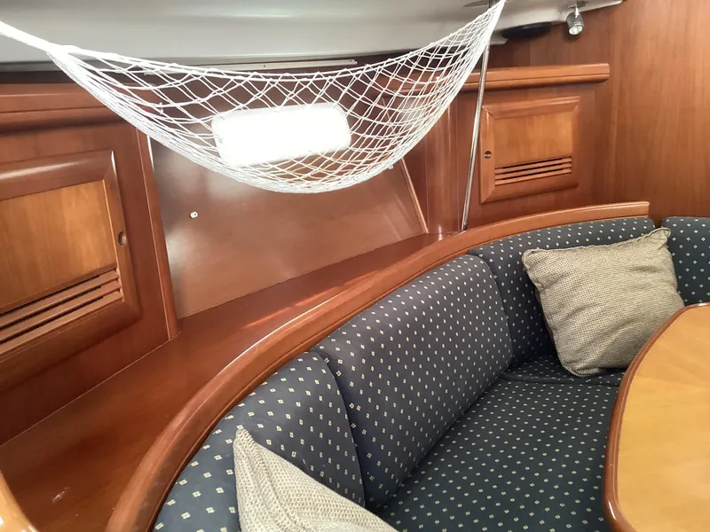 Slide: The Image of Cozy interior of 2002 Beneteau 393 sailboat with cushioned seating and net storage. - 24