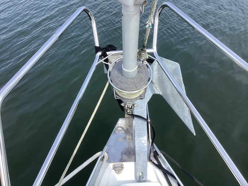 Slide: The Image of Bow of 2002 Beneteau 393 sailboat with anchor and railing over water. - 27