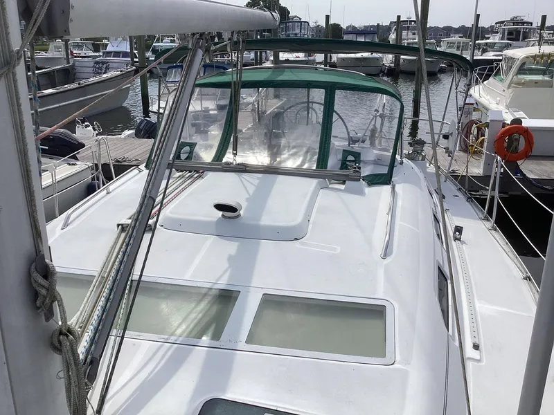 Slide: The Image of Beneteau 393 sailboat, 2002 model, docked at marina with green canopy. - 28