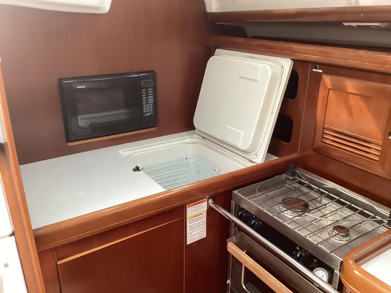 Slide: The Image of Beneteau 393 yacht kitchen with stove, microwave, and open fridge, 2002 model. - 29