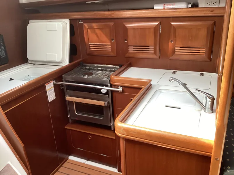 Slide: The Image of Wooden kitchen interior of 2002 Beneteau 393 yacht with stove and sink. - 30