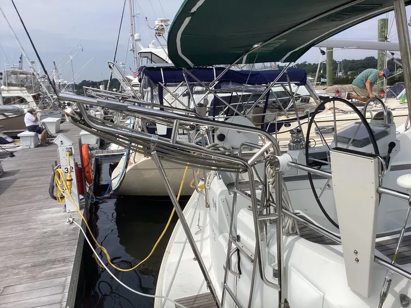 Slide: The Image of Beneteau 393 sailboat from 2002 docked at a marina, featuring stainless steel railings. - 31