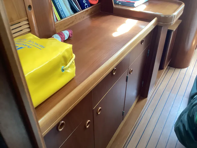 Slide: The Image of Interior of 2002 Beneteau 393 sailboat with wooden cabinetry and nautical accessories. - 7