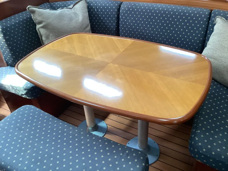 Slide: The Image of Interior of 2002 Beneteau 393 yacht with wooden table and patterned seating. - 8