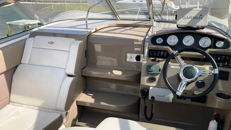 Slide: The Image of 2016 Regal 28 Express boat interior with Garmin navigation system and beige seating. - 12