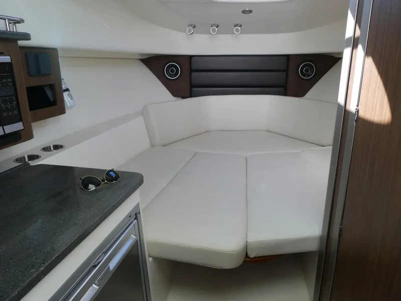 Slide: The Image of 2024 Boston Whaler 285 Conquest cabin interior with white seating and modern amenities. - 11