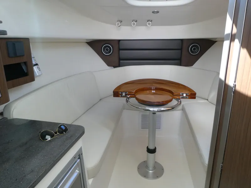 Slide: The Image of 2024 Boston Whaler 285 Conquest cabin interior with seating and table. - 12