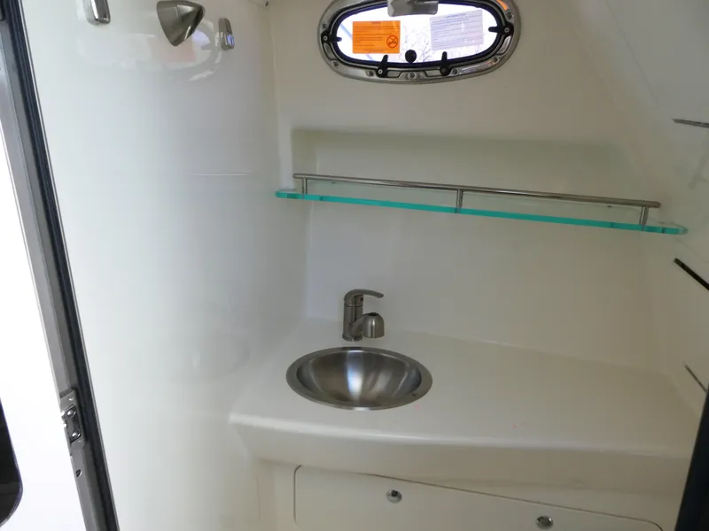 Slide: The Image of 2024 Boston Whaler 285 Conquest interior sink area with modern design and compact storage. - 16