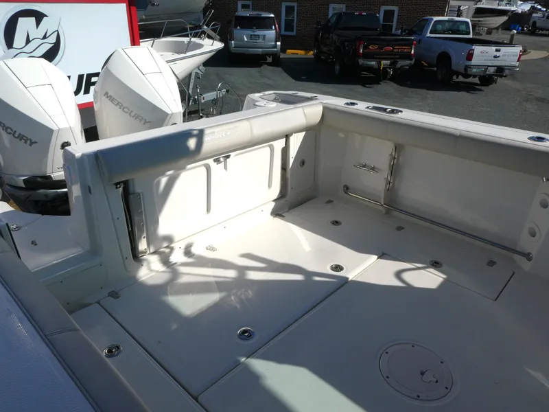 Slide: The Image of 2024 Boston Whaler 285 Conquest boat deck with Mercury engines in a marina setting. - 4