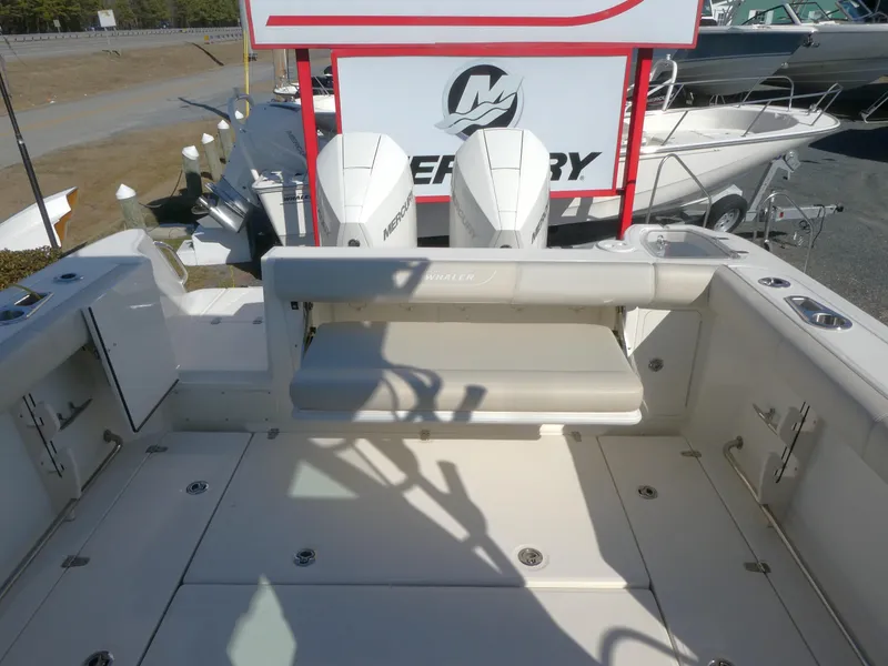 Slide: The Image of 2024 Boston Whaler 285 Conquest boat deck with Mercury engines in a marina. - 5