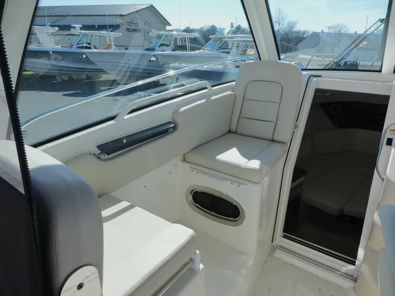 Slide: The Image of 2024 Boston Whaler 285 Conquest interior seating area with white upholstery. - 8