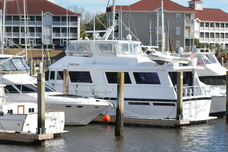 Slide: The Image of 1989 Viking Motor Yacht docked at marina with nearby boats and waterfront buildings. - 1
