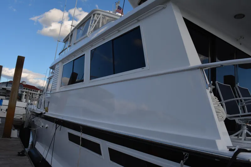 Slide: The Image of 1989 Viking Motor Yacht docked, showcasing sleek white exterior and large windows. - 10