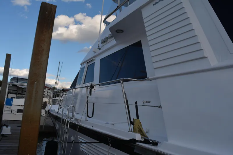 Slide: The Image of 1989 Viking Motor Yacht docked at marina under blue sky. - 11
