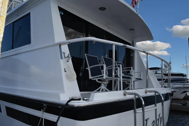 Slide: The Image of 1989 Viking Motor Yacht with deck chairs, docked under a blue sky. - 12
