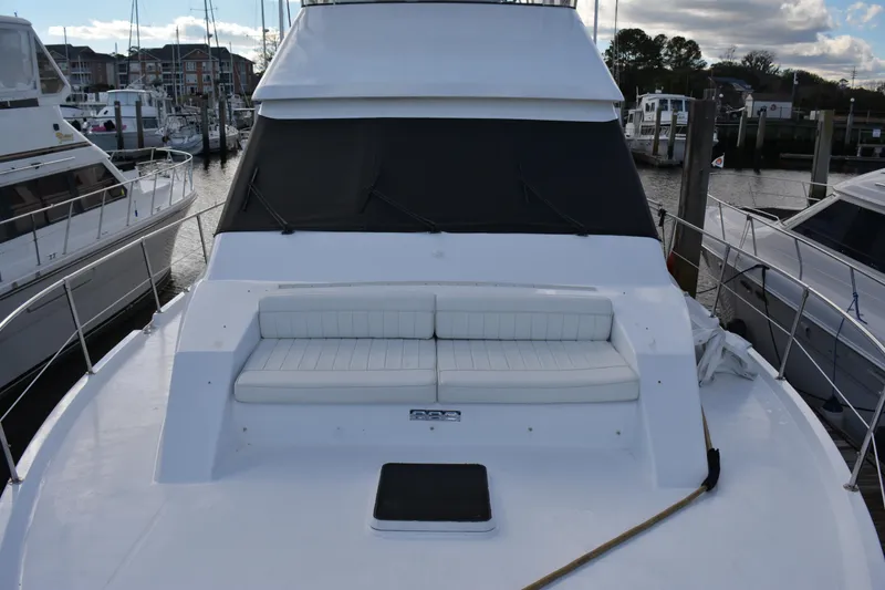Slide: The Image of 1989 Viking Motor Yacht with white seating on deck, docked at marina. - 14