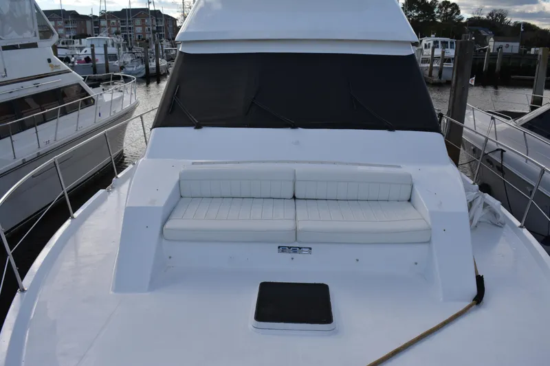 Slide: The Image of 1989 Viking Motor Yacht with white seating on deck, docked at marina. - 15