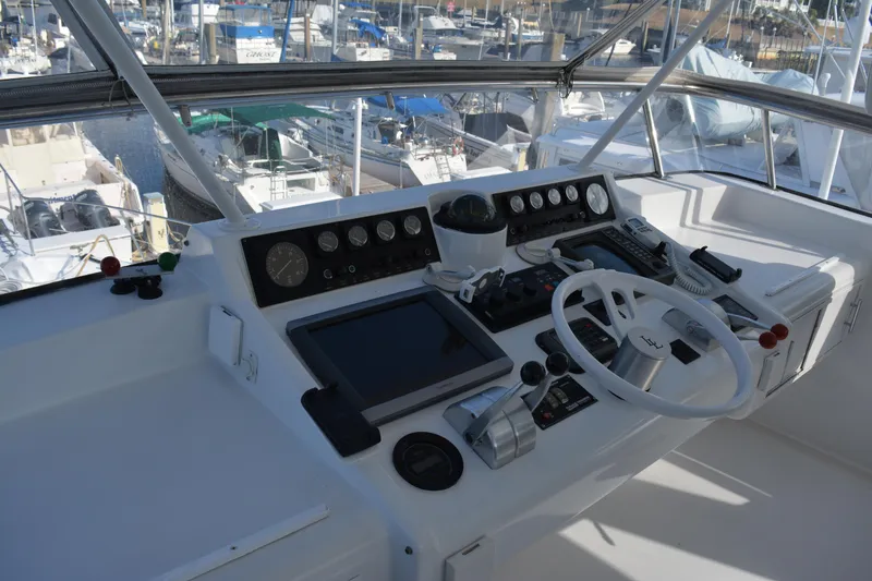 Slide: The Image of 1989 Viking Motor Yacht helm with navigation instruments and steering wheel, docked at marina. - 22