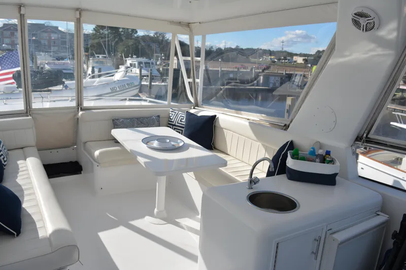 Slide: The Image of 1989 Viking Motor Yacht interior with seating, table, and sink in marina setting. - 24