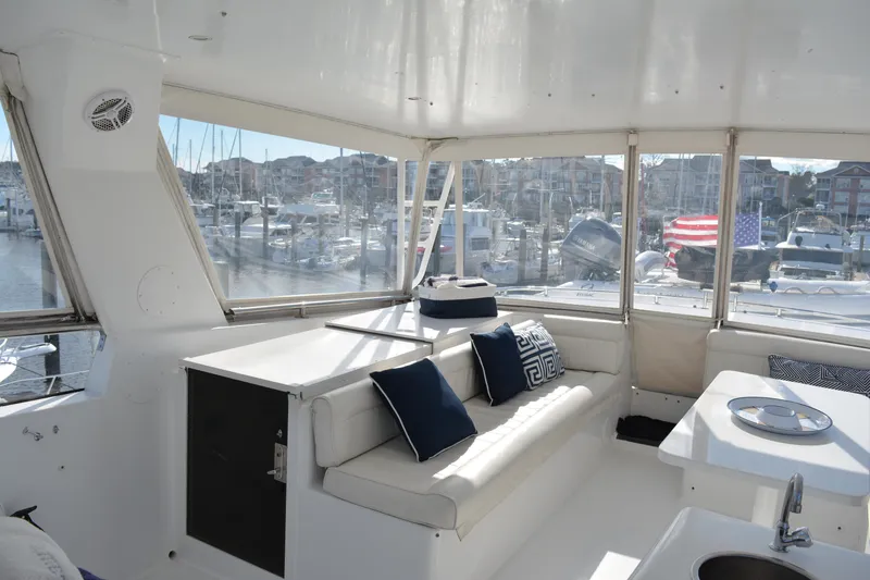 Slide: The Image of Interior of 1989 Viking Motor Yacht with white seating and marina view. - 25