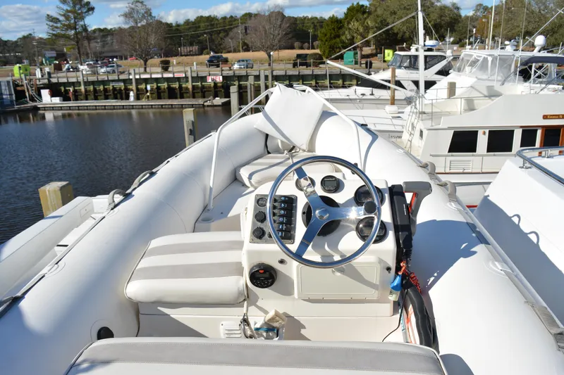 Slide: The Image of 1989 Viking Motor Yacht helm with steering wheel and controls, docked at marina. - 38