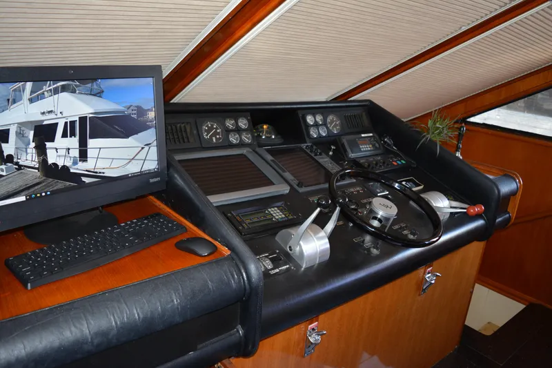 Slide: The Image of 1989 Viking Motor Yacht helm with steering wheel, controls, and computer display. - 41