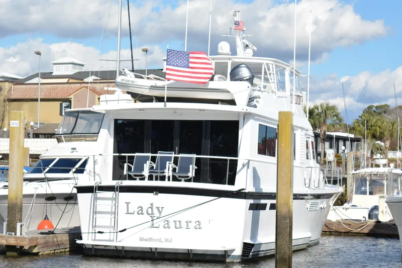 Slide: The Image of 1989 Viking motor yacht docked, displaying American flag, named "Lady Laura." - 7