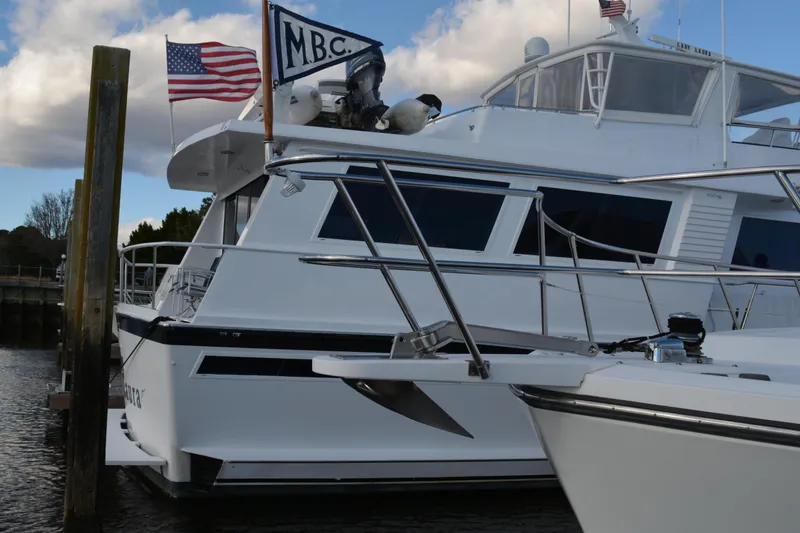 Slide: The Image of 1989 Viking Motor Yacht docked with flags, featuring sleek design and spacious deck. - 9