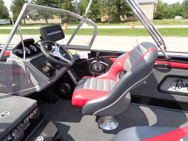 Slide: The Image of 2023 Ranger 2080MS A Pack boat interior with red and gray seating, steering wheel, and dashboard. - 24