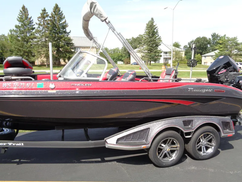 Slide: The Image of 2023 Ranger 2080MS A Pack boat, red and black, parked on a trailer. - 3
