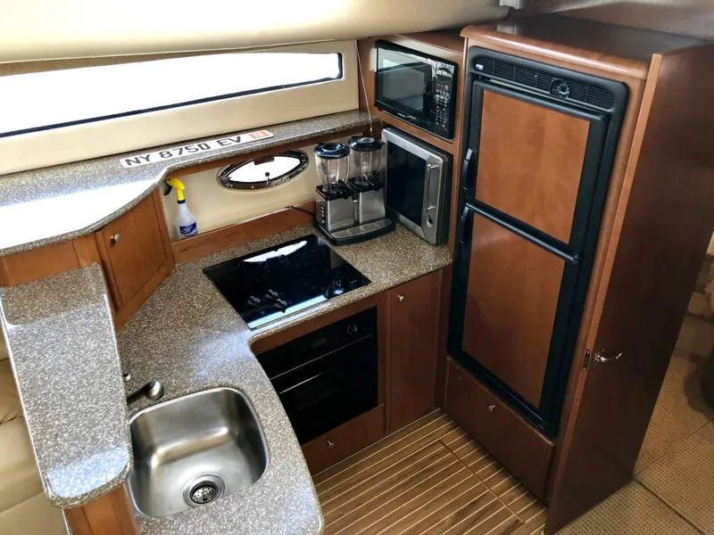 Slide: The Image of 2005 Meridian 459 Motoryacht kitchen with sink, stove, microwave, and refrigerator. - 11