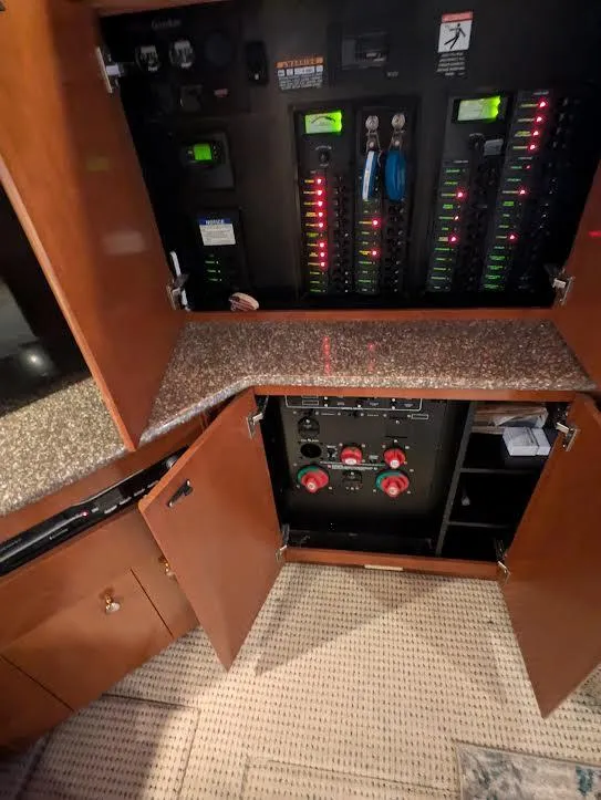 Slide: The Image of Electrical panel inside 2005 Meridian 459 Motoryacht, featuring control switches and storage compartments. - 12