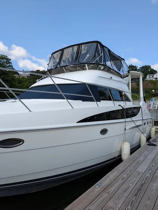 Slide: The Image of 2005 Meridian 459 Motoryacht docked, featuring sleek design and spacious upper deck. - 2