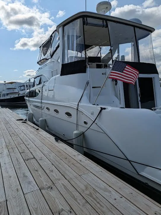 Slide: The Image of 2005 Meridian 459 Motoryacht docked with American flag, under a partly cloudy sky. - 3