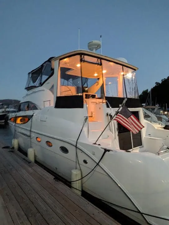 Slide: The Image of 2005 Meridian 459 Motoryacht docked at sunset with illuminated interior and American flag. - 5