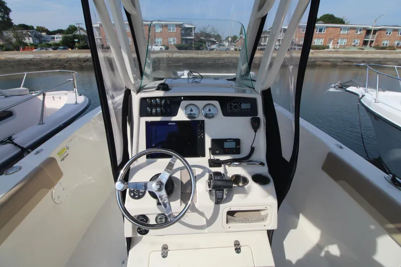 Slide: The Image of 2017 Sailfish 236 CC boat console with steering wheel, gauges, and navigation equipment. - 12