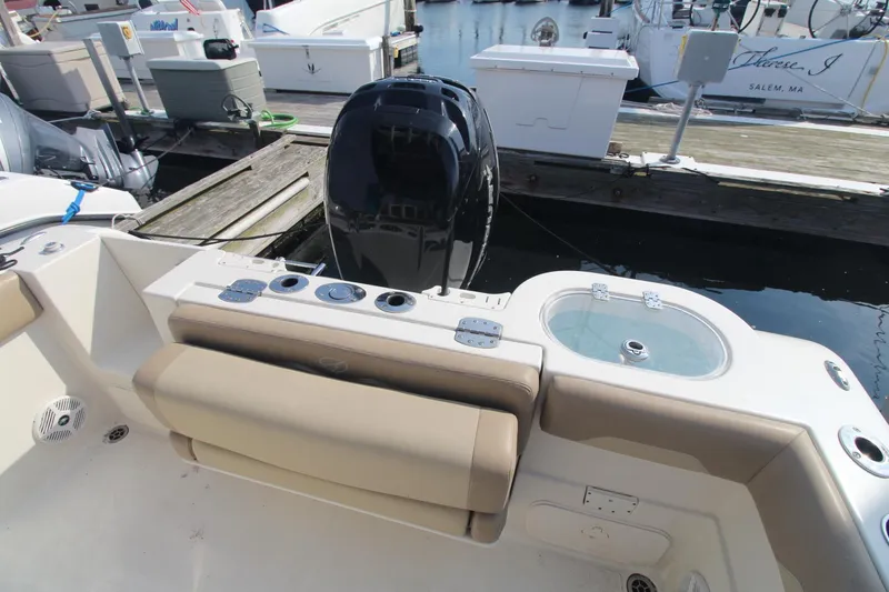 Slide: The Image of 2017 Sailfish 236 CC boat with beige seating and outboard motor at dock. - 17