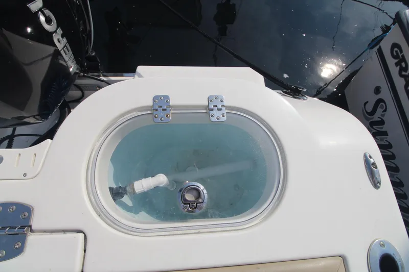 Slide: The Image of Livewell on 2017 Sailfish 236 CC boat, filled with water, featuring a clear lid. - 18