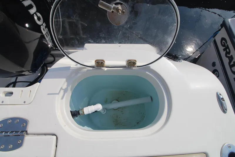 Slide: The Image of Livewell on 2017 Sailfish 236 CC boat with open lid and visible plumbing. - 19
