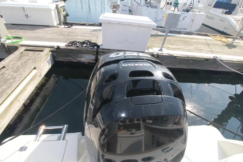 Slide: The Image of 2017 Sailfish 236 CC boat with a black outboard motor at a marina dock. - 23