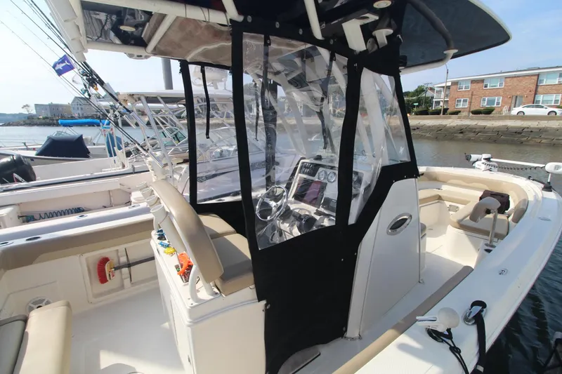 Slide: The Image of 2017 Sailfish 236 CC boat with enclosed helm, docked at marina. - 28